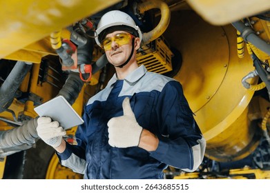 Worker mechanic with tablet computer under mining truck in garage, service center of industrial machinery. - Powered by Shutterstock - Get 15% off with code: PIKWIZARD15