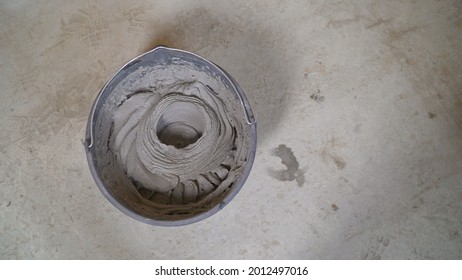 Worker Mixes The Mortar. Worker's Hands Mixing Grout For Filling Space Between Ceramic Tiles. A Worker Fills A Bucket With Mortar.