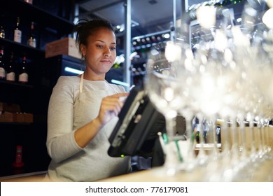 Worker of modern pub, bar or restaurant standing in front of computer monitor and giving new orders to kitchen - Shutterstock ID 776179081