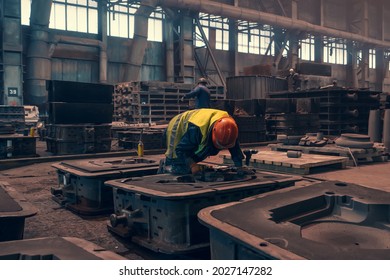 Worker with molds for metal cast in metallurgical plant foundry. Heavy industry