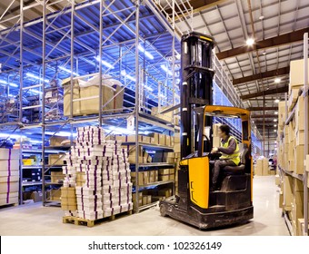 Worker in the motion on forklift in the large modern warehouse - Powered by Shutterstock