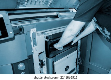 The worker moves the working camera of the 3D printer into the 3D printer. Large industrial 3D printer printing with polyamide powder in a production laboratory. Multi Jet Fusion. Industrial equipment
