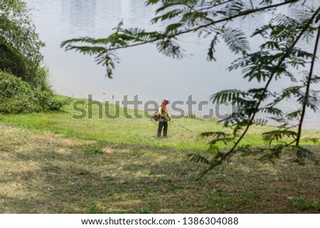 worker mowing grass at the park