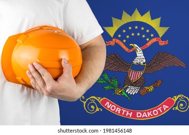 Worker with North Dakota flag on background for working on labor day. Construction concept.