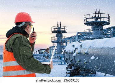 Worker At The Oil Field , Natural Gas Storage In The Background.Refinery , Oil And Natural Gas 