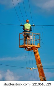 Worker On Aerial Platform Repair Damaged Wire At Height. Man In Hardhat Repair Broken Wire On Truck Crane Worker In Lift Bucket Repair Power Line