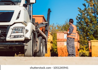 Worker On Construction Site Unloading Container For Waste From Truck Using Remote Control 