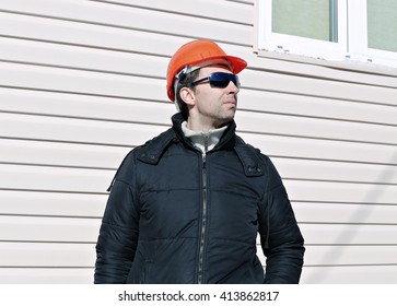 Worker on a construction site in winter looks and compares work done