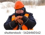 Worker on the ice of a frozen lake with bogr in his hand on ice mining