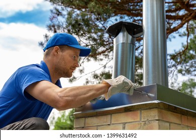 worker on the roof installing tin cap on the brick chimney