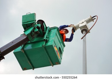 A Worker On A Sky Lift Doing Maintenance Work On An Explosive Proof Security Camera.