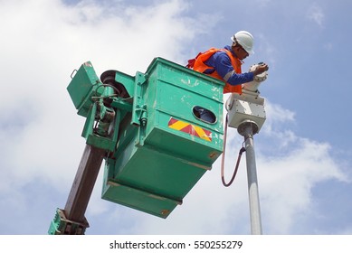 A Worker On A Sky Lift Doing Maintenance Work On An Explosive Proof Security Camera.