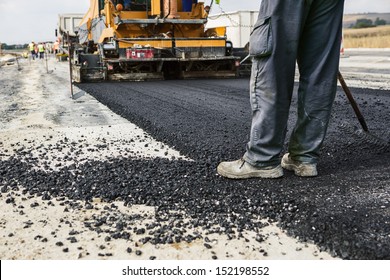 Worker Operating Asphalt Paver Machine During Road Construction And Repairing Works