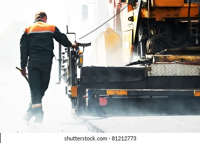 Worker Operating Asphalt Paver Machine During Road Construction And Repairing Works