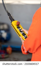 A worker is operating remote swtich to control overhead crane at the factory warehouse. Industrial working action photo. Close-up.