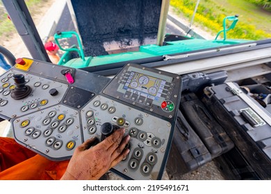 Worker, Operator Is Controlling Tarmac Road Laying Machine With Handlebars, Operating Joystick.