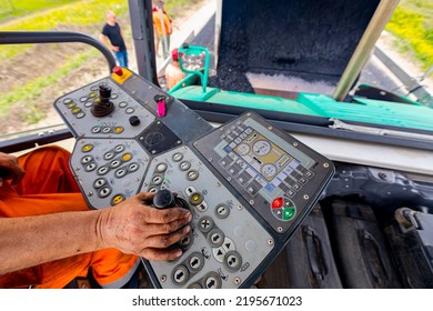 Worker, Operator Is Controlling Tarmac Road Laying Machine With Handlebars, Operating Joystick.