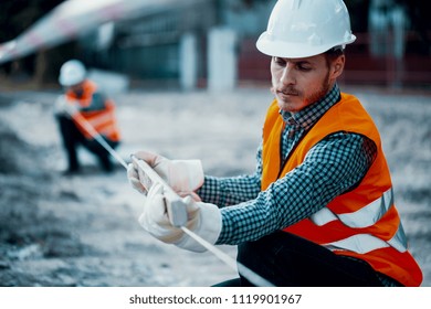 Worker in orange uniform and white helmet. Safety during roadworks