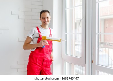 Worker In Overalls Setting Up New Windows In The Office