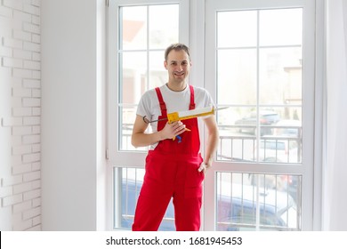 Worker In Overalls Setting Up New Windows In The Office