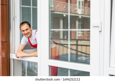 Worker In Overalls Setting Up New Windows In The Office