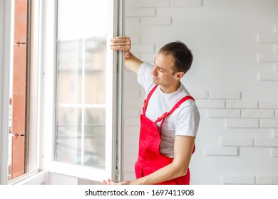 Worker In Overalls Setting Up New Windows In The Office