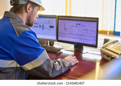Worker in overalls uses a linear telemechanics system to control the technological processes of the enterprise. Automated workplace of a dispatcher or operator of a modern enterprise - Shutterstock ID 2145681407