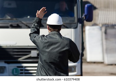 Worker Overlooking Work Site, Directing A Truck