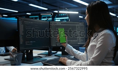 Worker overseeing data center using green screen mobile phone, ensuring system can handle networking tasks. IT expert in server room tracking network traffic with empty copy space smartphone, camera B