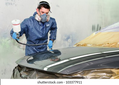 Worker Painting A Car In A Paint Booth,