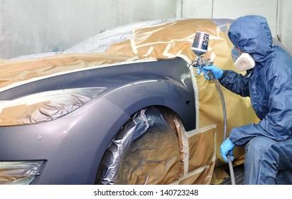 Worker Painting Car In A Paint Booth.