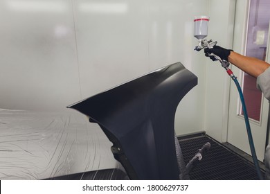 Worker Painting A Car In A Paint Booth.