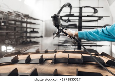 Worker Painting A Car Parts In A Paint Booth