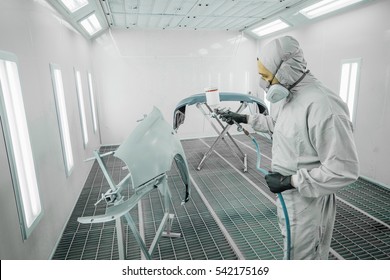 Worker Painting A Car Parts In A Paint Booth,