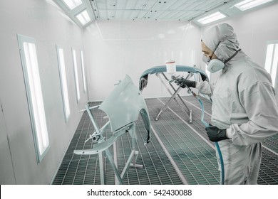 Worker Painting A Car Parts In A Paint Booth,