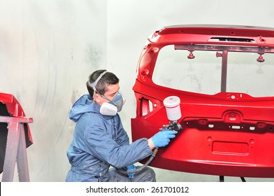 Worker Painting Red Car Part.