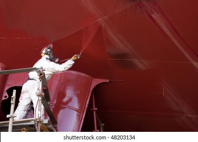 Worker Painting Ship Hull Using Airbrush Red Paint