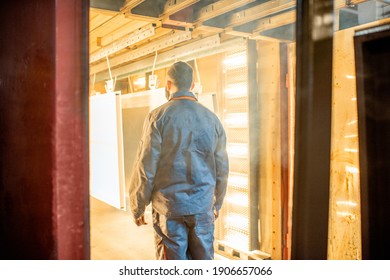 Worker Of The Painting Shop Checking Metal Products Into The Oven For Baking Powder Paint. Powder Coating Process At The Manufacturing. High Quality Photo