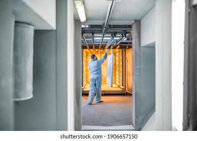 Worker Of The Painting Shop Pushing Metal Products Into The Oven For Baking Powder Paint. Powder Coating Process At The Manufacturing. High Quality Photo