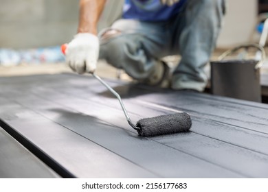 Worker Painting Steel Post In Construction Site.