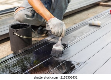 Worker Painting Steel Post In Construction Site.