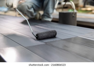 Worker Painting Steel Post In Construction Site.