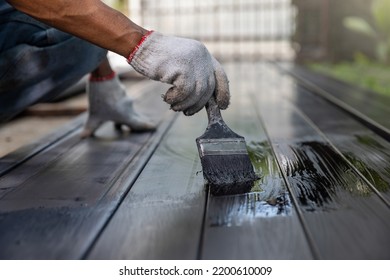 Worker Painting Steel Post In Construction Site.