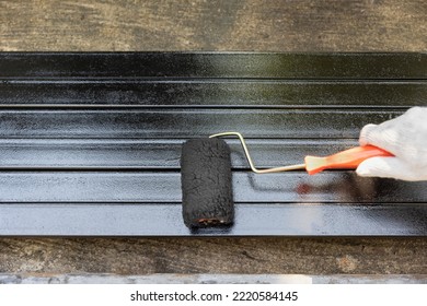 Worker Painting Steel Post In Construction Site.