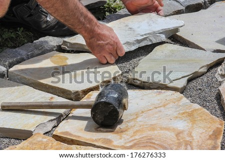 Worker with paver's dressing hammer