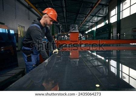 Worker performs a technological process in window production