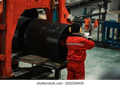 A Worker Of A Pipe-rolling Plant. Conveyor Line Of The Ferrous Metallurgy Enterprise. A Worker In A Uniform Is Engaged In Metal Welding