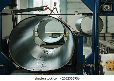 A Worker Of A Pipe-rolling Plant. Conveyor Line Of The Ferrous Metallurgy Enterprise. A Worker In A Uniform Is Engaged In Metal Welding