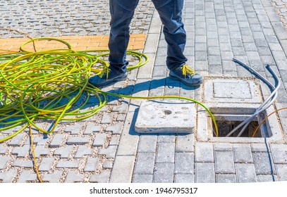 Worker Places Yellow-green Electric Vacs In A Pit To Complete An Underground Power Line