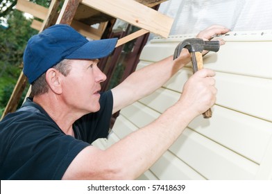 Worker Planking House With Plastic Siding Panels